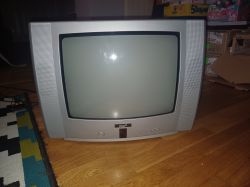 Stary telewizor kineskopowy marki Pro2 na drewnianej podłodze.