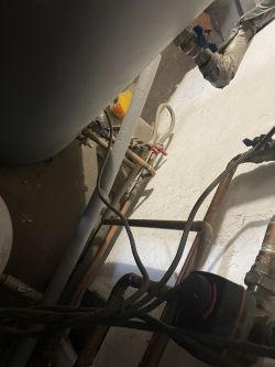 Fragment instalacji grzewczej z widocznymi rurami i zaworami