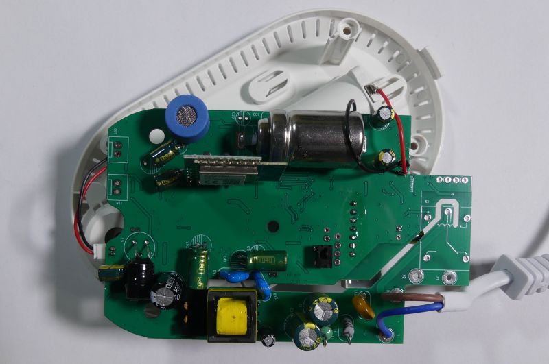 Wnętrze urządzenia elektronicznego z widoczną płytką PCB i komponentami