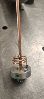 Photo of a handmade antenna with a coil and copper rod.