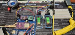 Electronics prototype with wires and two small displays showing vertical signal level bars