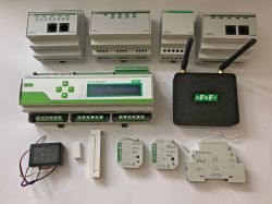 A set of F&amp;F home automation devices including control modules, a central unit, relays, and communication modules.