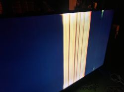 Telewizor z ciemnoniebieskim ekranem i szerokim pionowym pasem jasnych, kolorowych linii po prawej