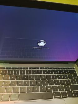 Ekran laptopa z ikoną obracającego globusa i adresem Apple na dole.