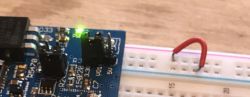Breadboard with a red wire connected to a blue electronic board.