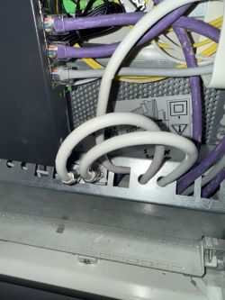 Zbliżenie na panel połączeń z kilkoma podłączonymi kablami w dekoderze.