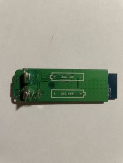 Door Sensor PCB with AAA Battery Slots Circuit of a door sensor on a green PCB with slots for two AAA batteries.