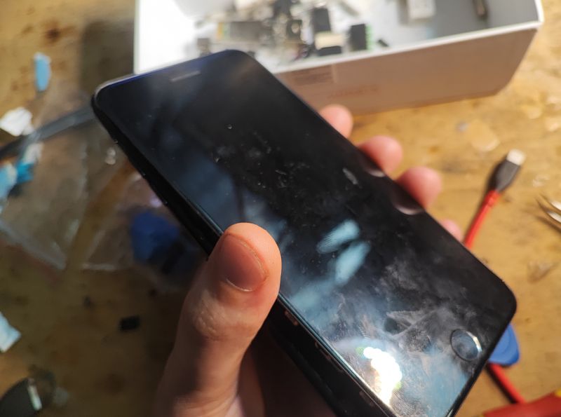 Smartphone Held During Battery Replacement Close-up of a smartphone with a dark screen held in a hand.