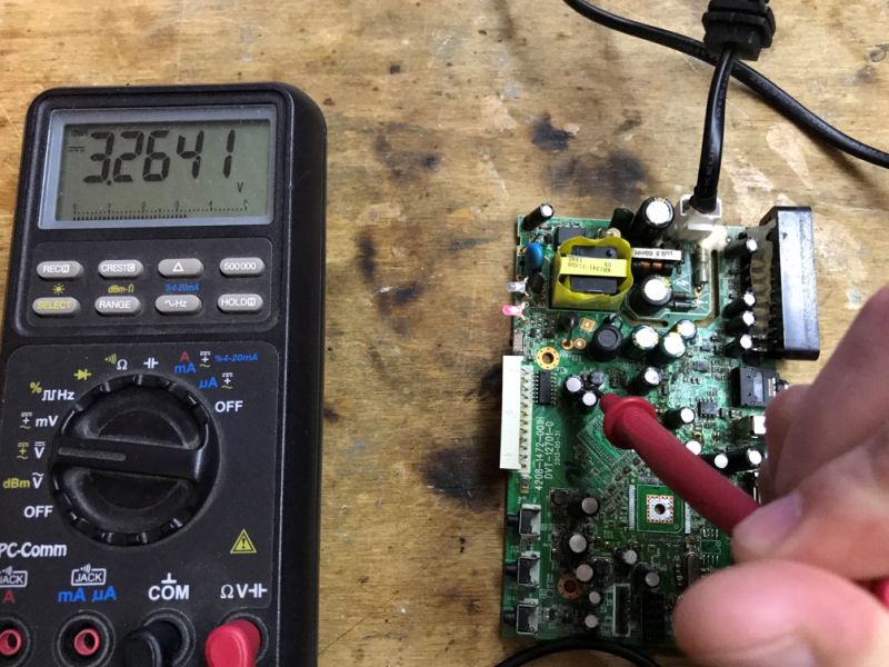 Voltage Measurement on Electronic Circuit Board Multimeter and electronic circuit board with voltage measurement