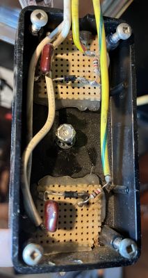Widok wnętrza urządzenia elektronicznego z lutowanymi elementami na płytkach drukowanych.