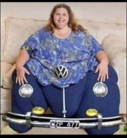 Kobieta siedząca na kanapie z nałożonym na dolną część ciała fotomontażem przedstawiającym przednią część samochodu Volkswagen z czarnymi tablicami rejestracyjnymi.