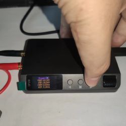 Close-up of DP100 power supply with connected wires and active OLED display