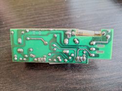 Zielona płytka PCB od spodu z lutami i bezpiecznikiem szklanym na górnej krawędzi