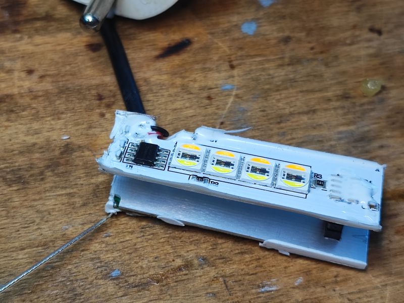 LED Board with Integrated Circuit Electronic board with LEDs and an integrated circuit on a wooden surface.