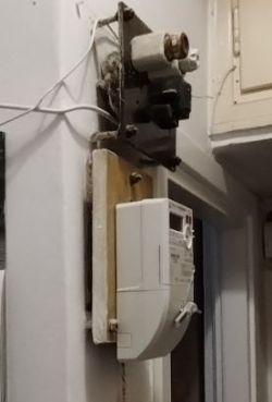 Stara tablica licznikowa w mieszkaniu z przewodami aluminiowymi.