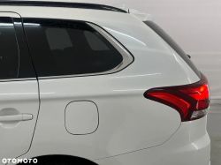 Rear part of a white SUV with visible taillights and fuel cap.