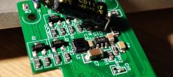 Close-up of Circuit Board with Electronic Components Close-up of a green circuit board with various electronic components, including a capacitor and pin labels.