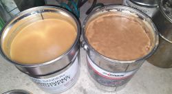 Dwa otwarte wiadra z woskiem konserwującym: po lewej Mike Sanders, po prawej Axenol.