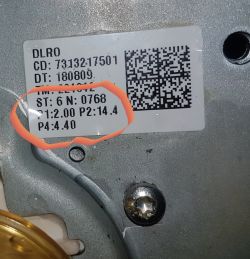 Etykieta na urządzeniu z numerami części i kodem QR, część numerów zakreślona.