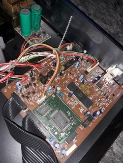 Wnętrze urządzenia elektronicznego z widocznym obwodem drukowanym i przewodami.