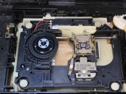 Wnętrze odtwarzacza DVD z widocznymi elementami mechanicznymi.