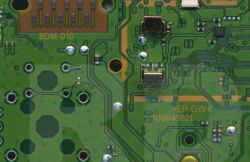 Zbliżenie na płytkę PCB z elementami SMD, w tym kondensatorami ceramicznymi.