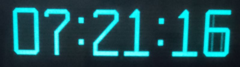 Zbliżenie na wyświetlacz VFD pokazujący czas 07:21:16.