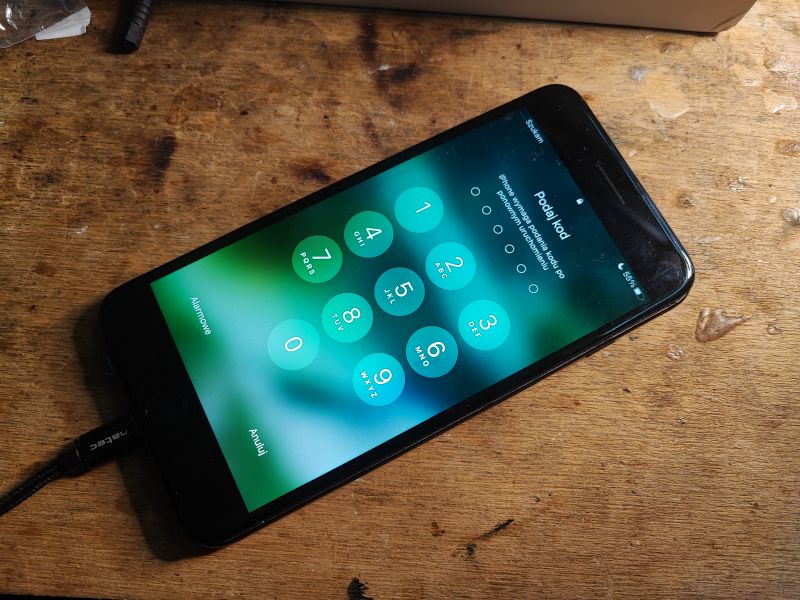 iPhone on Lock Screen after Battery Replacement iPhone displaying lock screen on a wooden table