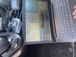 Laptop z wyświetlonymi danymi diagnostycznymi Audi A5 wewnątrz samochodu.