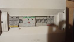 Panel elektryczny z czerwonym światłem na jednym z bezpieczników.