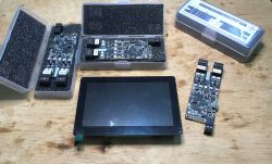 Electronic modules and screen on a wooden surface.