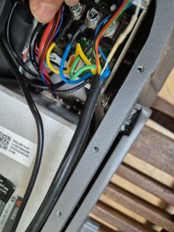 Zbliżenie na wnętrze sterownika z widocznymi kolorowymi kablami i złączami.