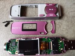 Rozebrany odtwarzacz MP3 Sony z demontowanymi częściami na stole.