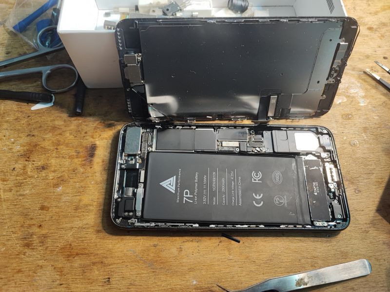Battery Replacement in iPhone 7 Plus Opened iPhone 7 Plus with a new battery visible and tools on the workbench.