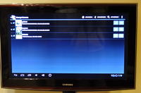 How can I stream footage from a camera at work to my TV at home via the internet?