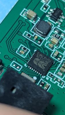 Close-up of an integrated circuit on a green printed circuit board.