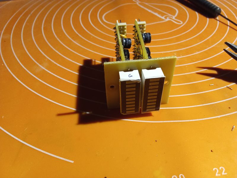 Electronic board with seven-segment displays on an orange mat.
