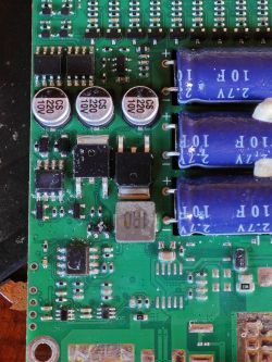 Zbliżenie na płytkę PCB z kondensatorami, układami SMD i uszkodzeniami