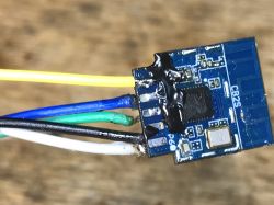 Close-up of a Tuya CB2S module with wires soldered to the QFN pad.
