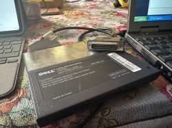 Zewnętrzny napęd dyskietek Dell podłączony do laptopa przez port równoległy.
