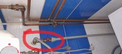 Podłączenie rur i zaworów w systemie wodnym z zaznaczoną problematyczną częścią.