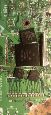 Zbliżenie zielonej płytki PCB z kilkoma układami scalonymi i widocznymi ścieżkami oraz oznaczeniami
