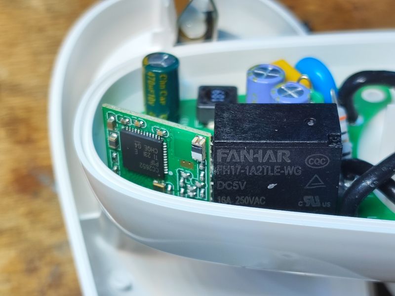 Zbliżenie na wnętrze inteligentnej wtyczki Sonoff S26R2ZB z widocznymi komponentami elektronicznymi.