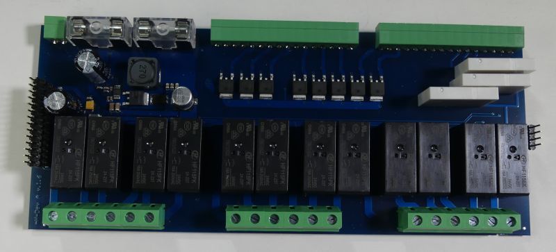 Niebieska płytka PCB z ośmioma przekaźnikami, zielonymi złączami śrubowymi i kondensatorami