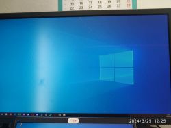 Obraz monitora z niebieskim tłem i logo systemu Windows z widocznymi artefaktami wyświetlania.