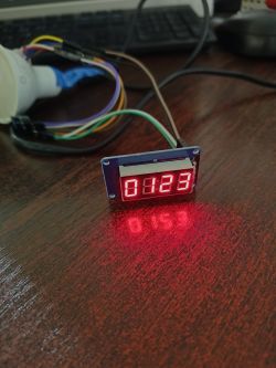 LED display showing the numbers 0123 on a wooden table.