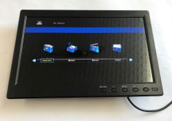 Small black monitor on a desk showing a media menu and the message “No Device”.