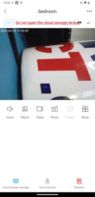 Close-up of a white object with red and blue geometric symbols, viewed from a security camera app.