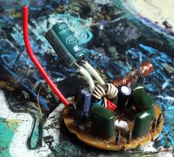 Close-up of a circuit board with coils, capacitors, and wires