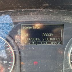 Deska rozdzielcza samochodu z wyświetlaczem pokazującym komunikat w języku niemieckim Reg.eenheden KSM PASSIV oraz licznik kilometrów.